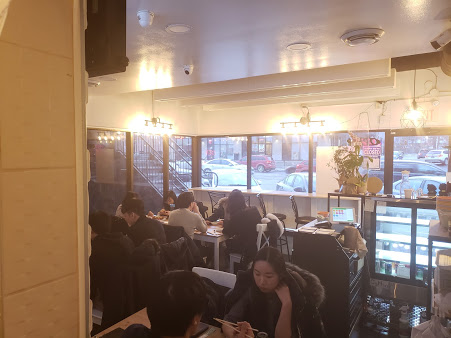 Customers sitting at tables and enjoying food inside Kim's Kitchen's restauraunt.