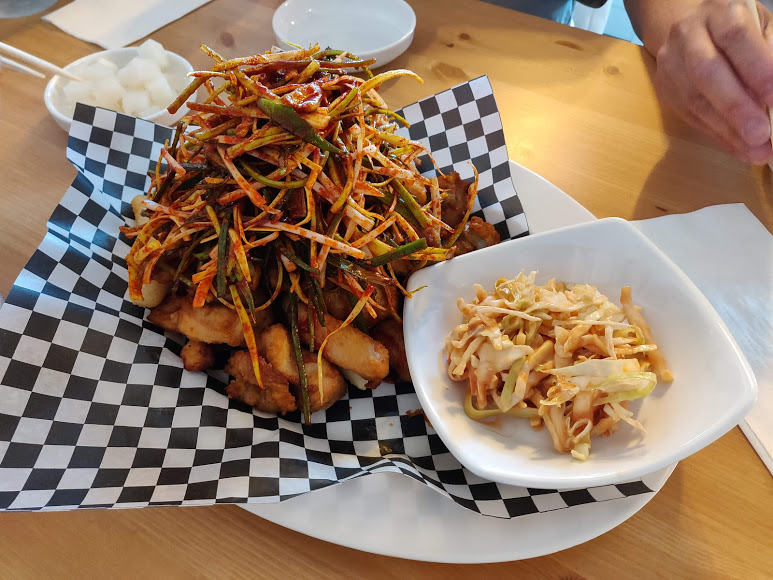 Korean boneless chicken topped with onions and peppers. Served with a side dish of coleslaw.