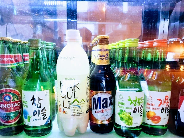 Korean specialty drinks aligned in a cold fridge.